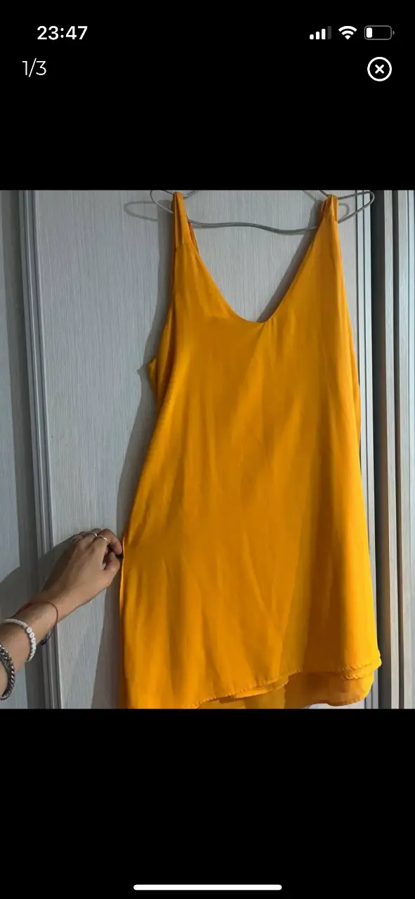 Vestido mini mostaza con escote en V y tiras anchas. Ideal para una salida de verano.