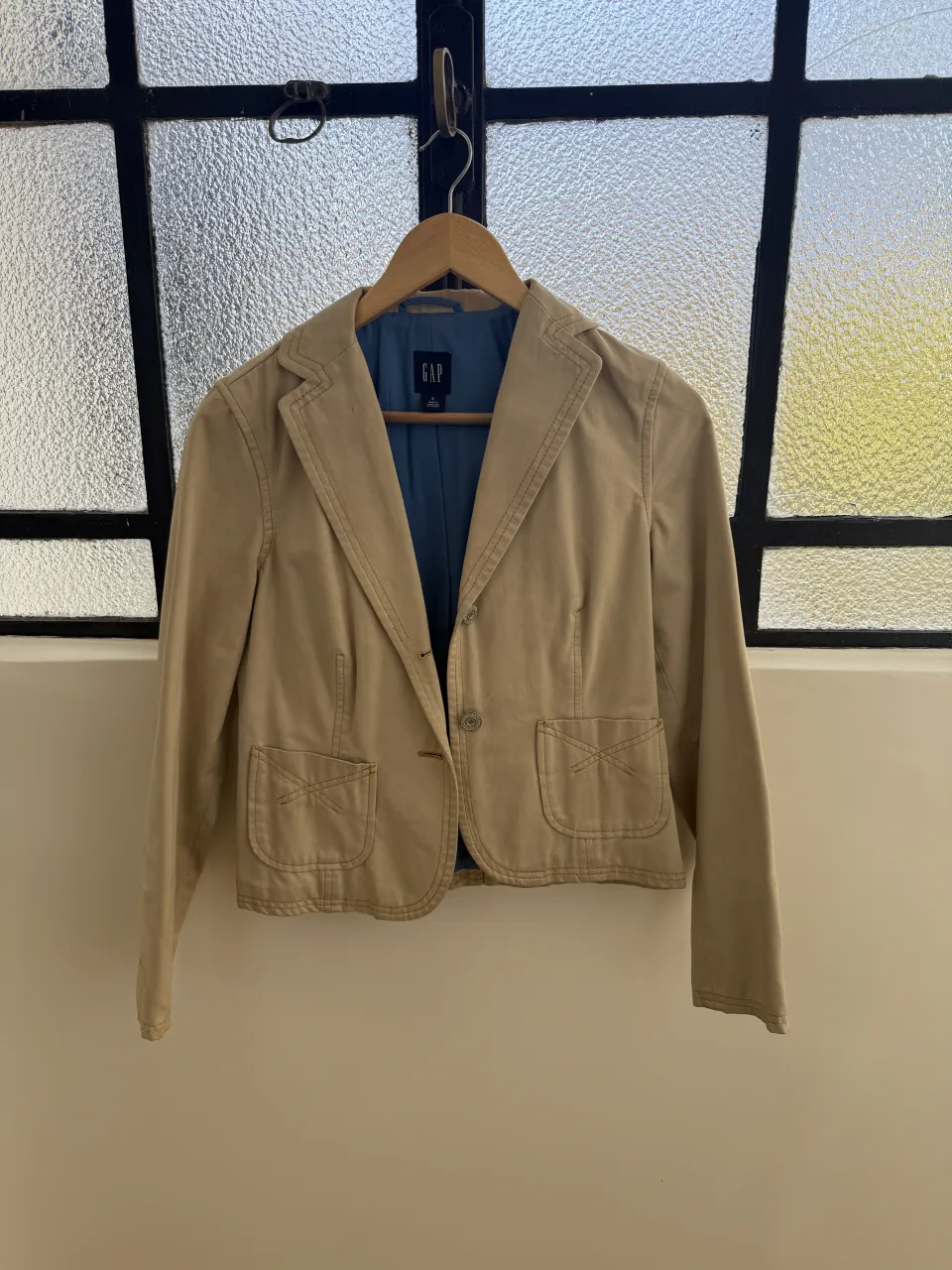 Blazer de gabardina color tiza, con forro azul. Ideal para un look casual o de trabajo.