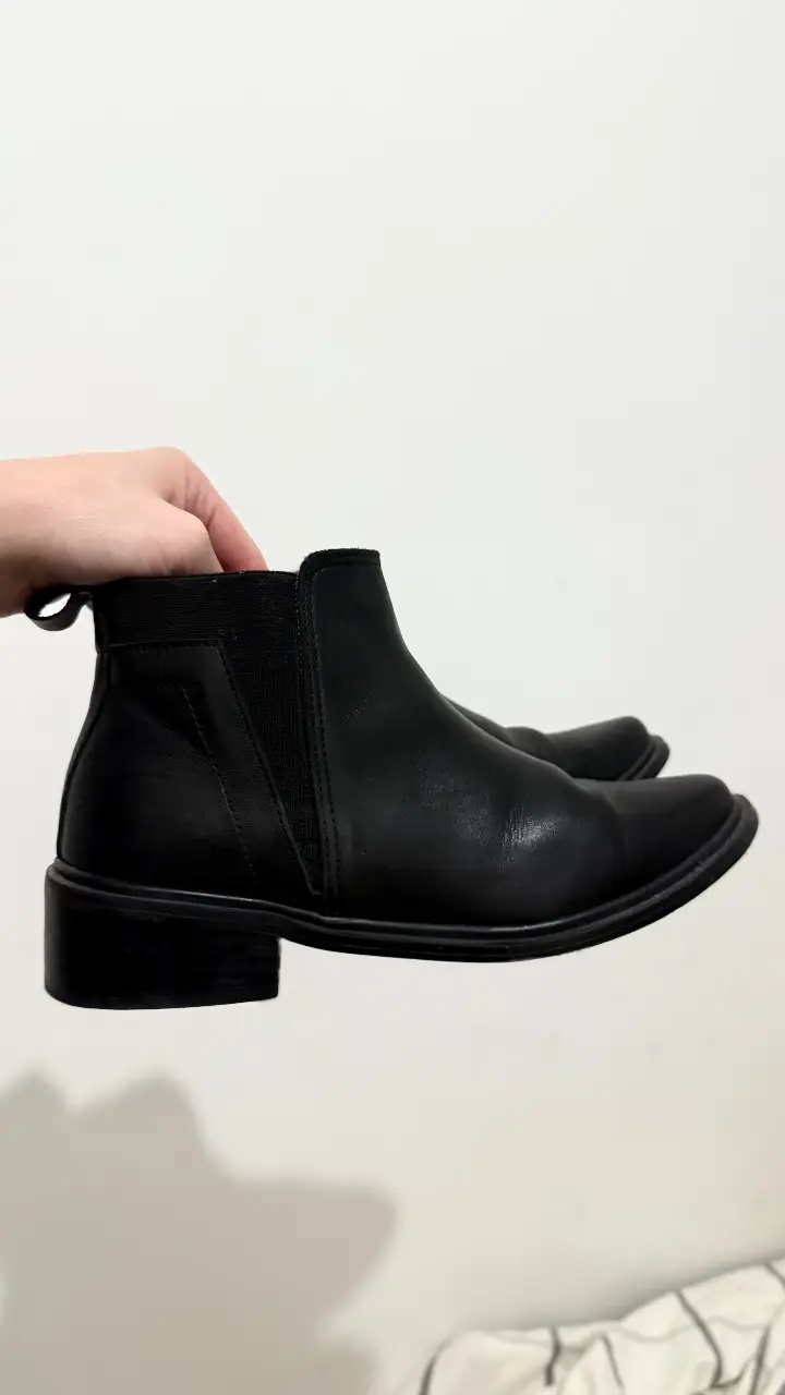 Botines negros de cuero, ideales para un look moderno y versátil. Perfectos para combinar con diferentes outfits.
