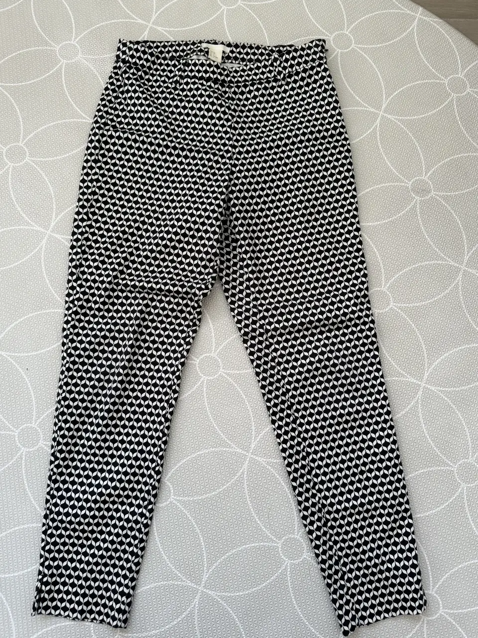 Pantalón sastrero de mujer con estampado geométrico en blanco y negro. Talle 34, de la marca H&M. Ideal para un look casual o de trabajo.