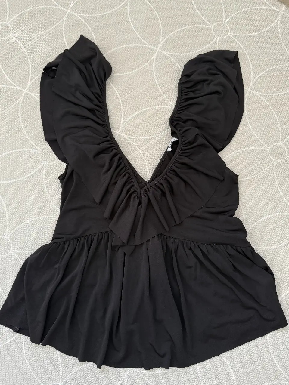 Blusa negra de Zara con volados en el cuello y en la parte inferior. Talle S.