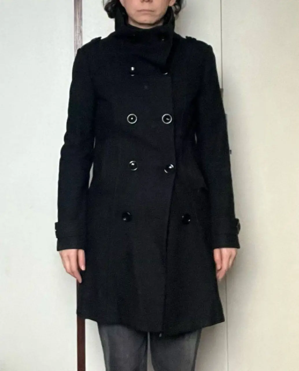 Tapado negro de mujer, de la marca H&M Divided. Confeccionado en paño, de corte entallado y largo a la rodilla. Posee cuello alto, doble botonadura y detalles en los hombros y puños. Ideal para un look elegante y abrigado.