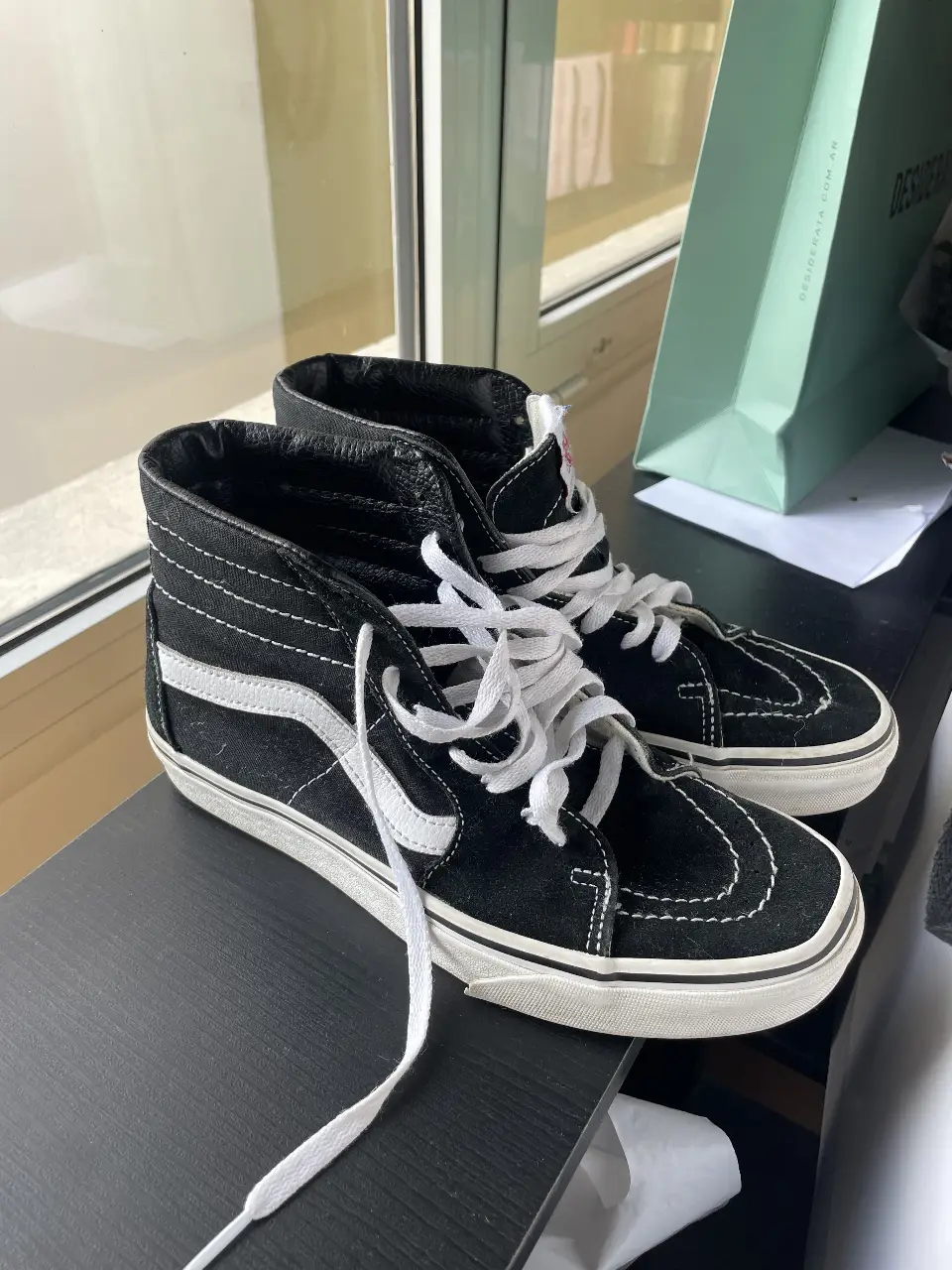 Zapatillas Vans Sk8-Hi negras con detalles en blanco. Clásico diseño de caña alta, ideales para un look urbano y cómodo. Perfectas para el día a día.