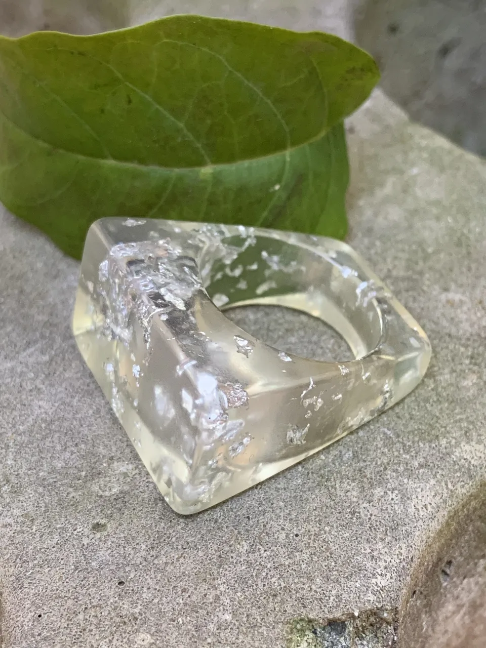 Anillo cuadrado transparente con detalles plateados. Resina 2 cm. 
Ideal para un look moderno y sofisticado.