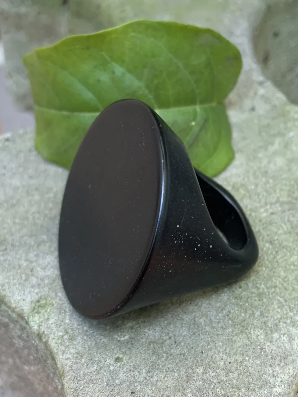 Anillo negro de diseño moderno y elegante. Ideal para complementar cualquier look, este anillo es perfecto para quienes buscan un accesorio sofisticado y atemporal. 2 cm int. Resina