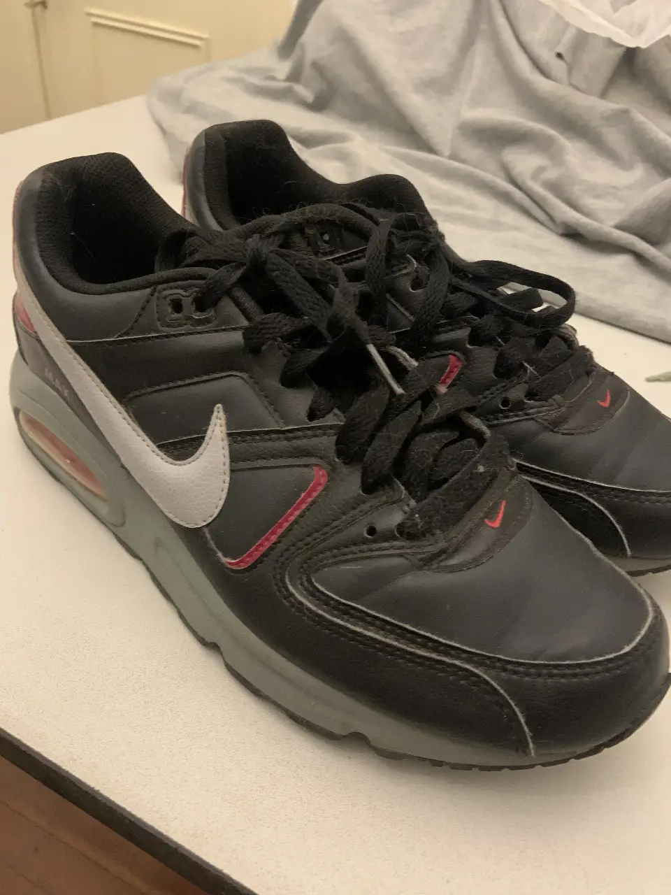 Zapatillas Nike Air Max negras con detalles en gris y rojo. Ideales para uso diario y actividades deportivas.