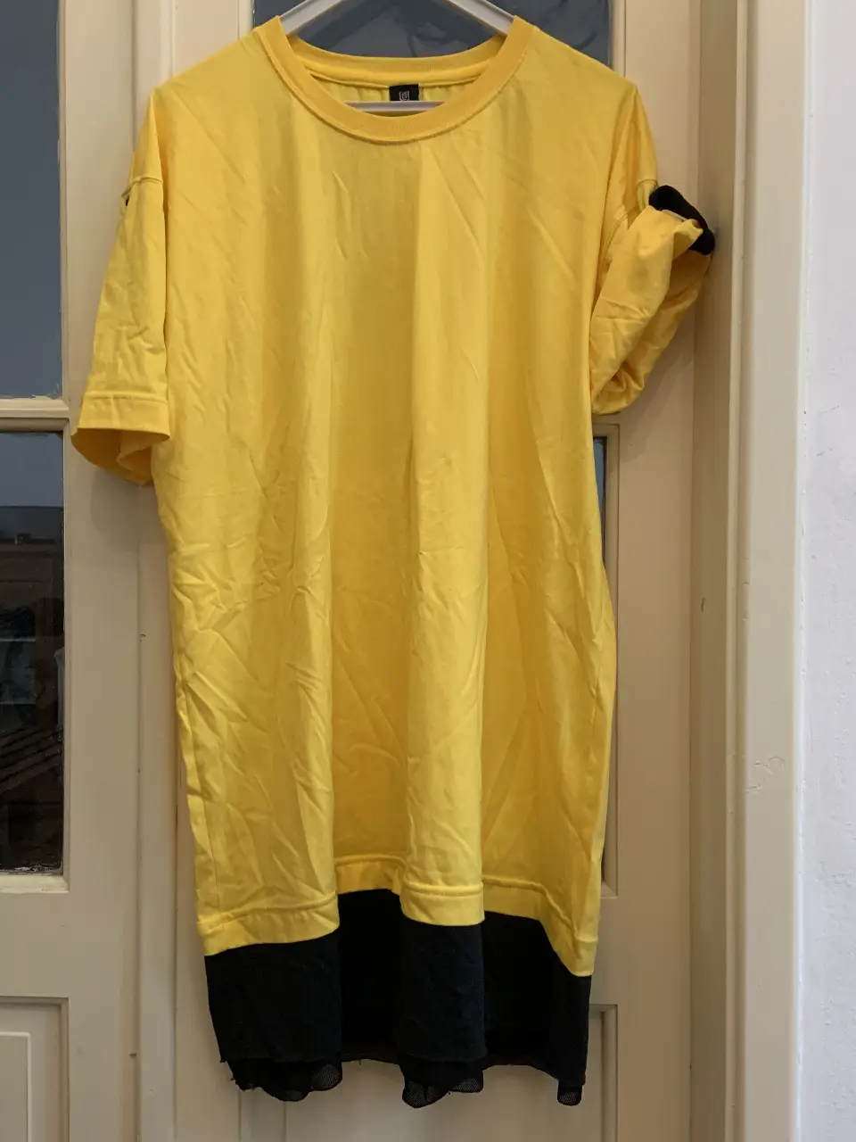 Vestido mini amarillo con detalles en negro. Diseño moderno y cómodo, ideal para un look casual y fresco.
