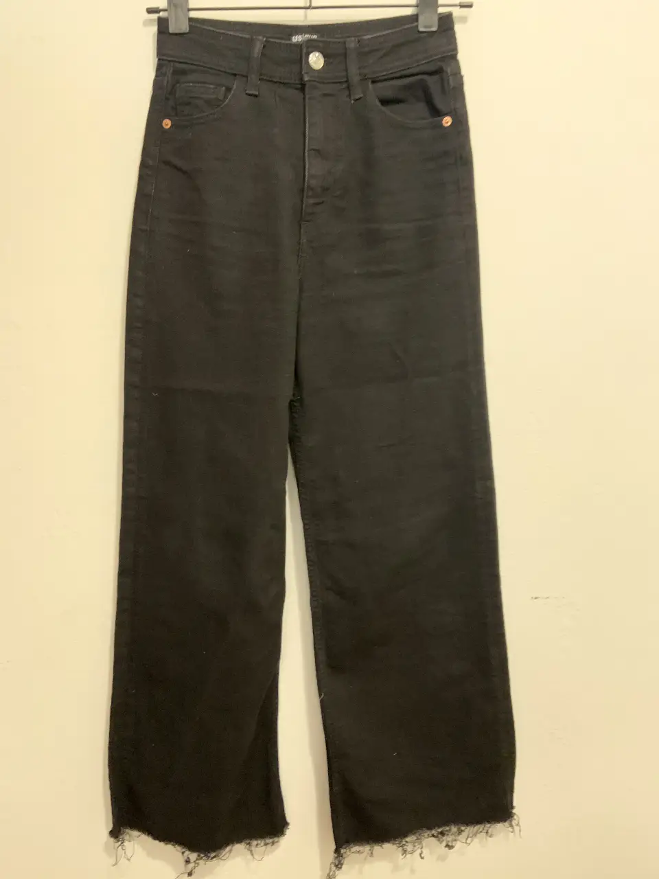 Pantalón de jean negro, corte recto, con detalle de flecos en el bajo. Talle 6 US, 36 EUR. Ideal para un look casual y moderno.