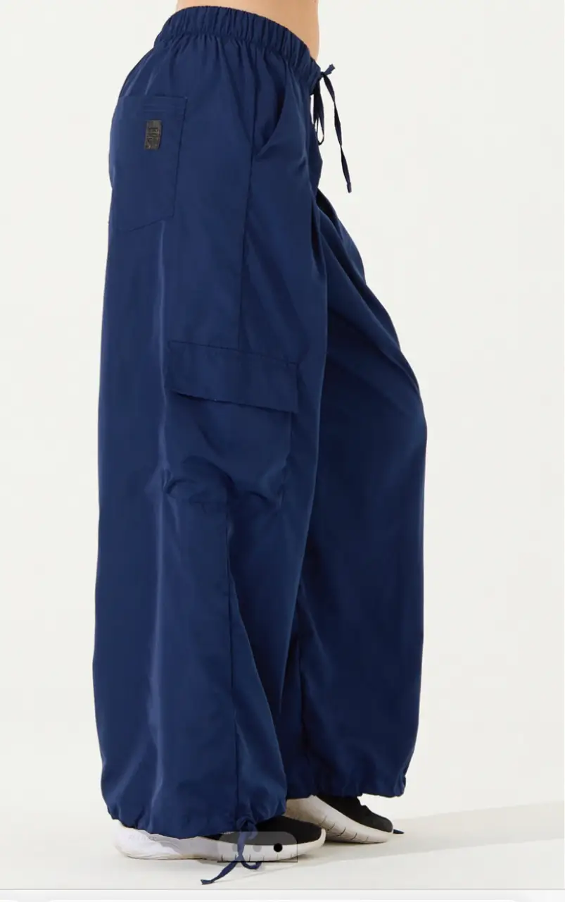 Pantalón Bomber. Pinzas en el Delantero. Bolsillos cargo en ambos laterales. Bolsillo trasero. Cintura con elastico embutido de 4 cm en la cintura. Cordón de ajuste en la cintura y el puño. Prenda de uso Deportivo/ urbano, con tiro medio y calce Amplio