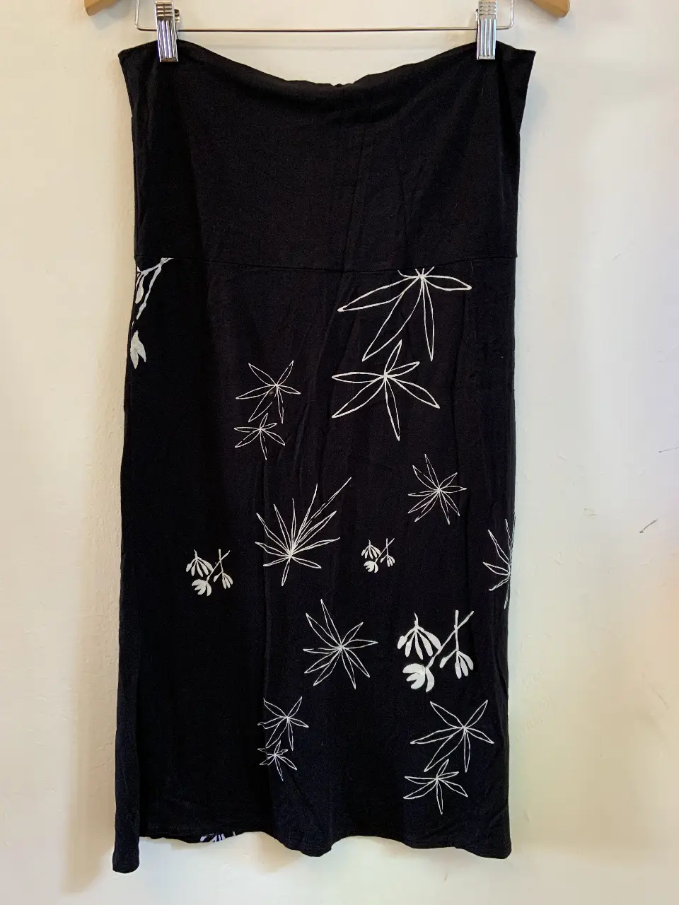 pollera negra, con estampado de hojas blancas. Ideal para una salida casual o una fiesta de verano.