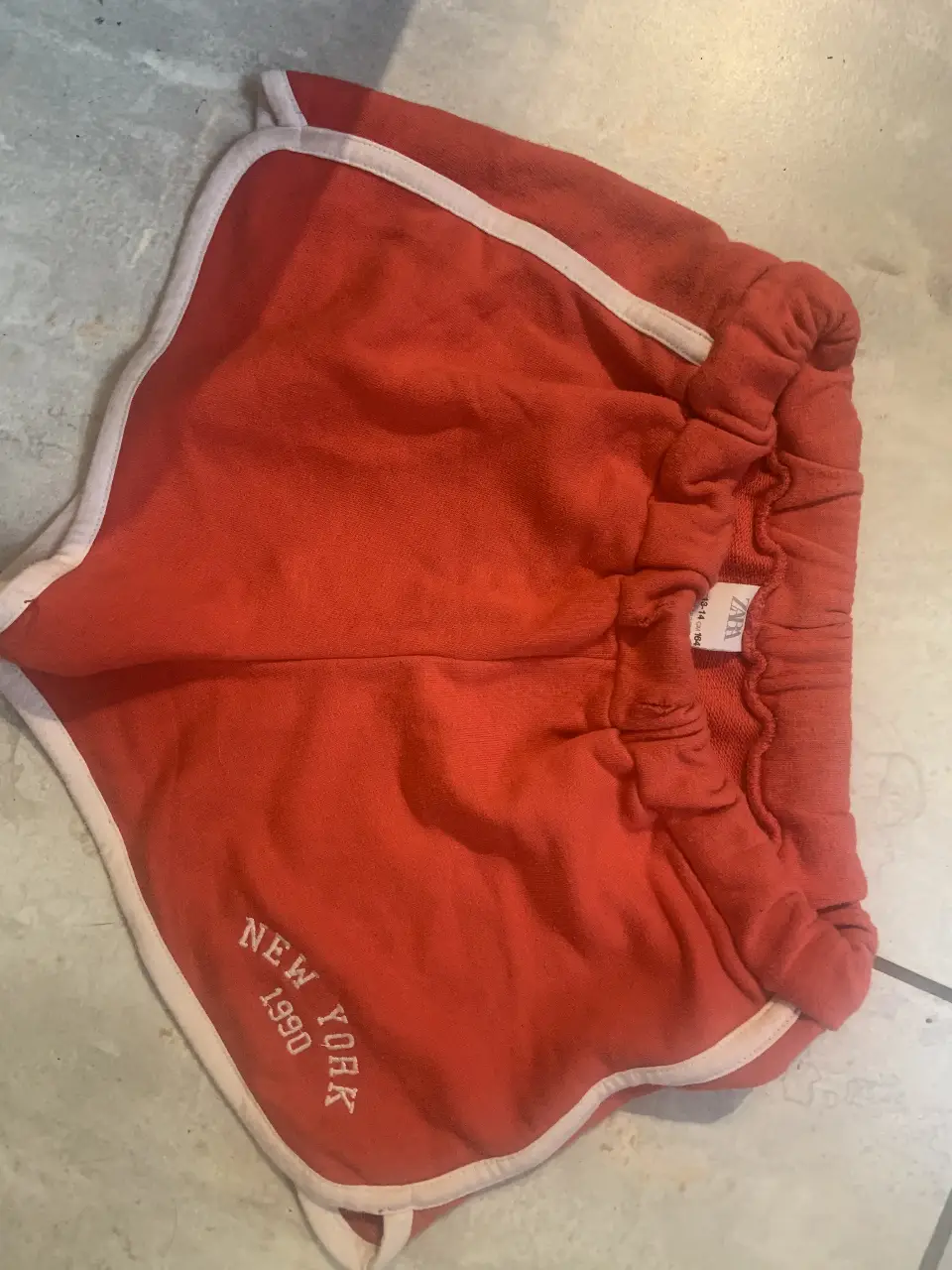 Short deportivo de algodón rojo con detalles en blanco. Estilo retro, ideal para actividades físicas o un look casual.