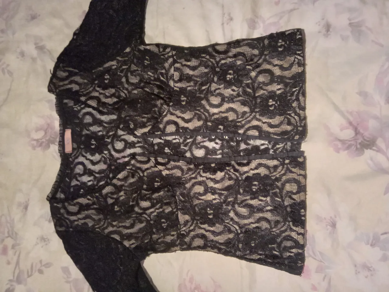 Blusa de encaje negra con mangas largas. Ideal para un look elegante y sofisticado.