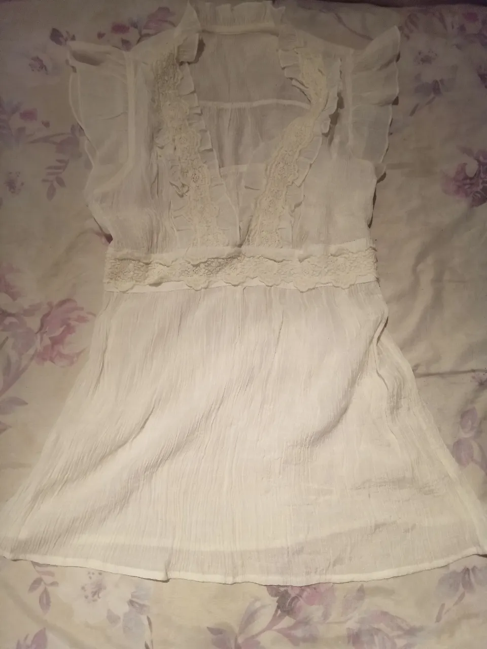 Blusa blanca de gasa con detalles de encaje y volados. Ideal para un look romántico y fresco.