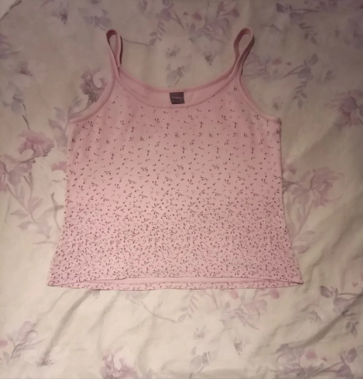 Musculosa rosa con estampa de flores pequeñas en tonos oscuros.