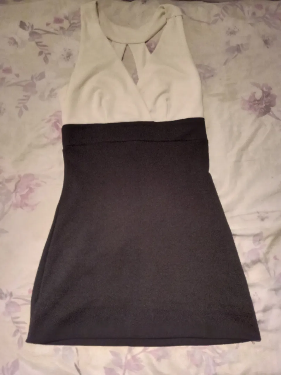 Vestido corto de fiesta, con la parte superior en color blanco y la inferior en negro. Diseño cruzado en el escote y corte a la cintura. Ideal para eventos o salidas.