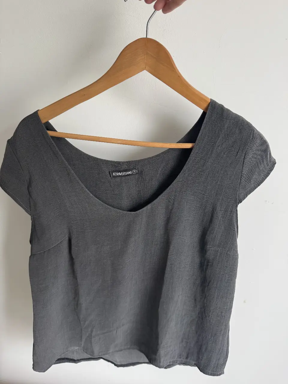 Blusa gris de mujer, con cuello en V y mangas cortas.