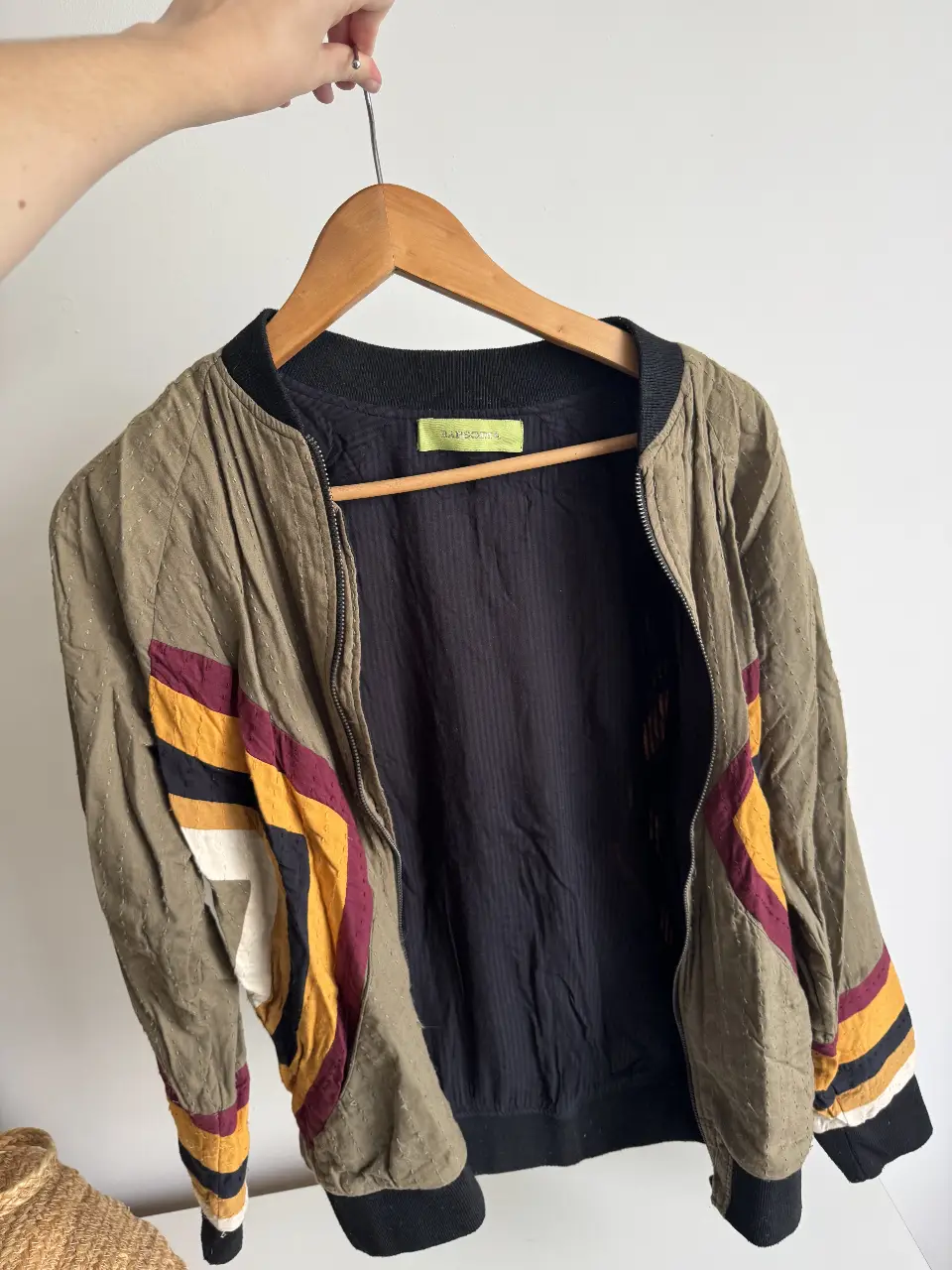 Campera bomber de tela con detalles en colores vibrantes. Diseño con cierre frontal y puños tejidos. Ideal para un look casual y con estilo.