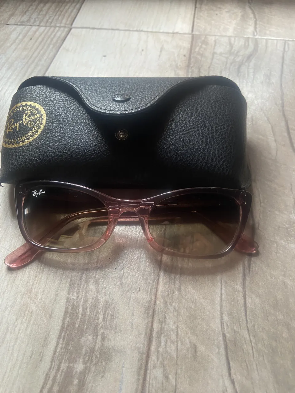 Lentes de sol Ray-Ban, modelo Wayfarer, color rosa con detalles glitter. Incluyen estuche original.