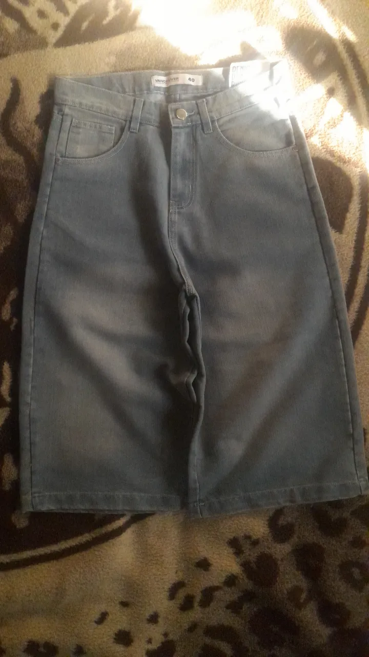 Shorts de jean tiro alto, color azul claro con detalles desgastados y un pequeño bordado en el bolsillo trasero. Perfectos para un look casual de verano.