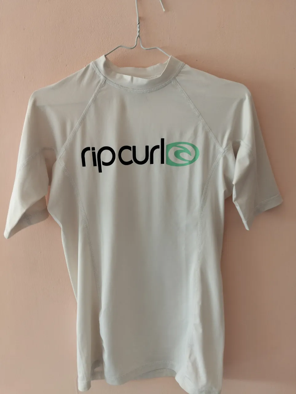 Remera deportiva de manga corta Rip Curl para mujer, ideal para actividades acuáticas. Con protección UPF 50+ y el logo de la marca estampado.