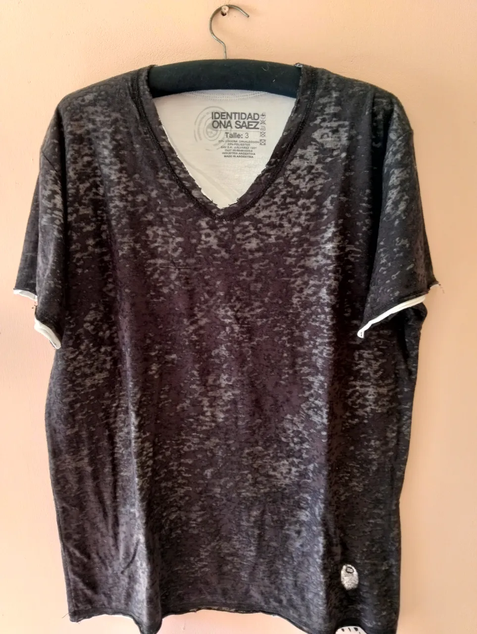 Remera negra con cuello en V, de la marca Ona Saez, con un diseño jaspeado, reversible. Ideal para un look casual y moderno.