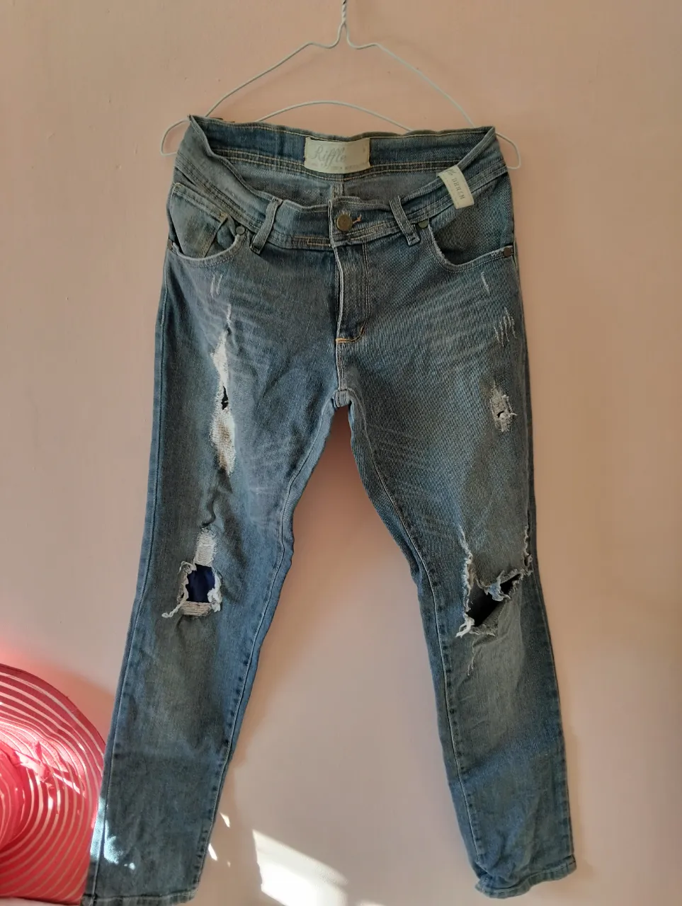 Jeans de mujer, tiro medio, con roturas y detalles desgastados. Marca Rifle. Ideal para un look casual y moderno.