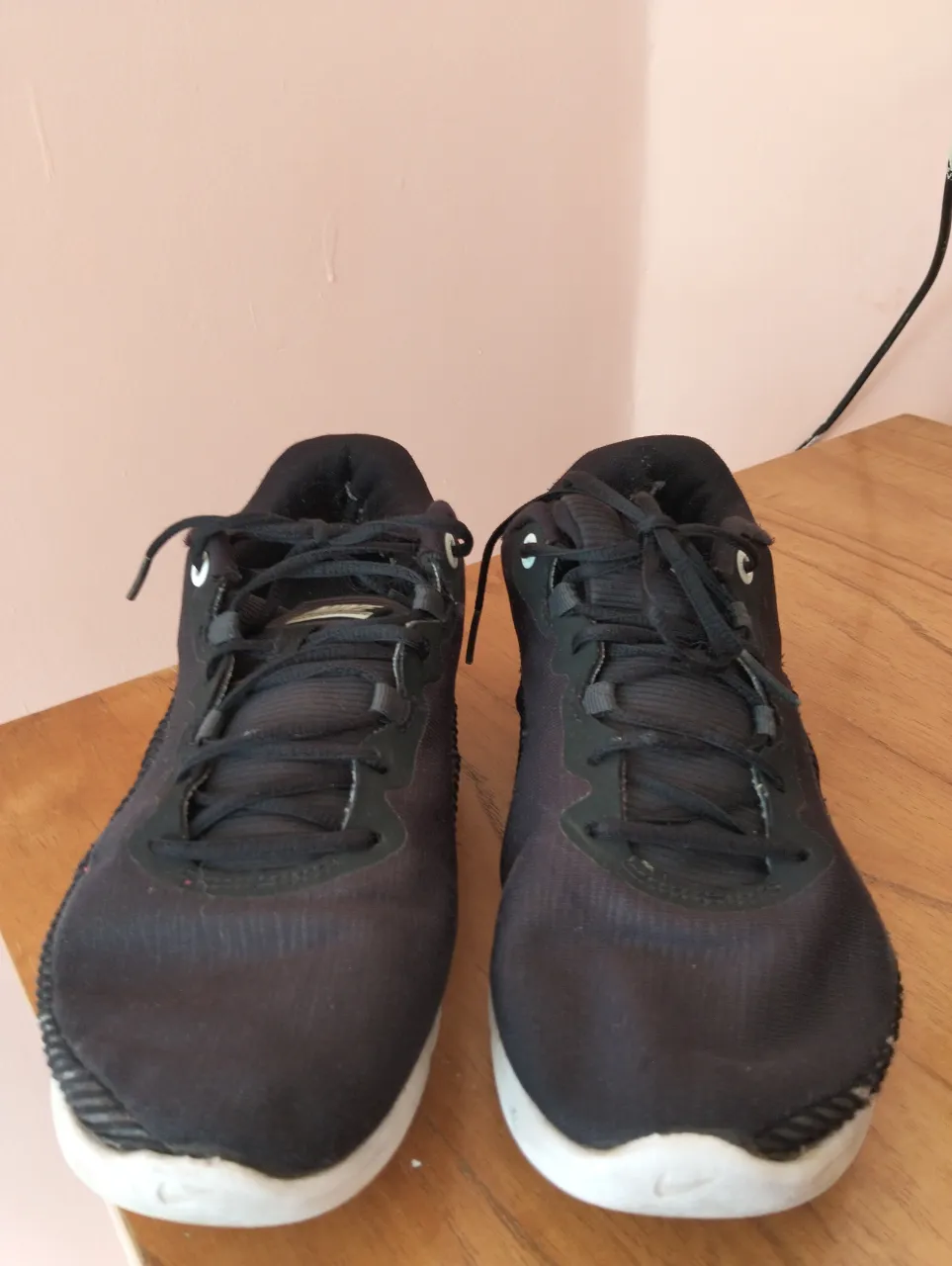 Zapatillas deportivas negras con suela blanca y detalles de la marca. Ideales para running y entrenamiento.
