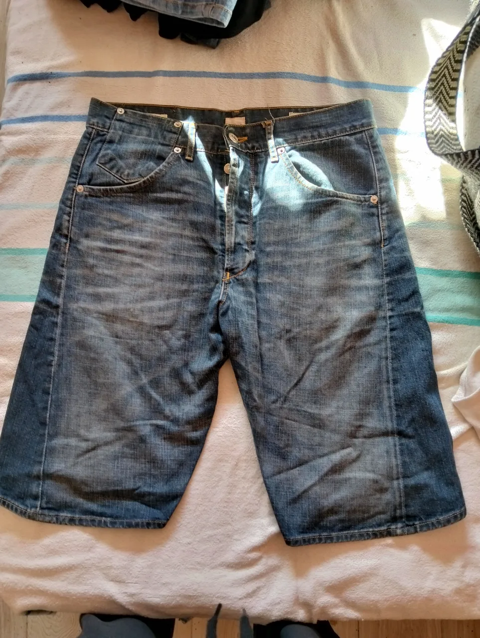 Short de jean azul gastado, ideal para un look casual y relajado. Perfecto para el verano, este short de tiro medio es un básico que no puede faltar en tu guardarropa. Combinalo con remeras, camisas o tops para crear diferentes estilos.
