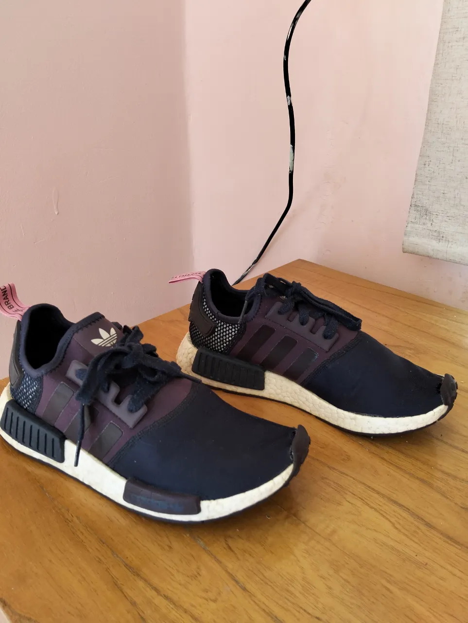 Zapatillas Adidas NMD en color azul y violeta. Diseño moderno y cómodo, ideales para uso diario. Detalles de la marca en la lengüeta y talón. Suela blanca con detalles en negro.
