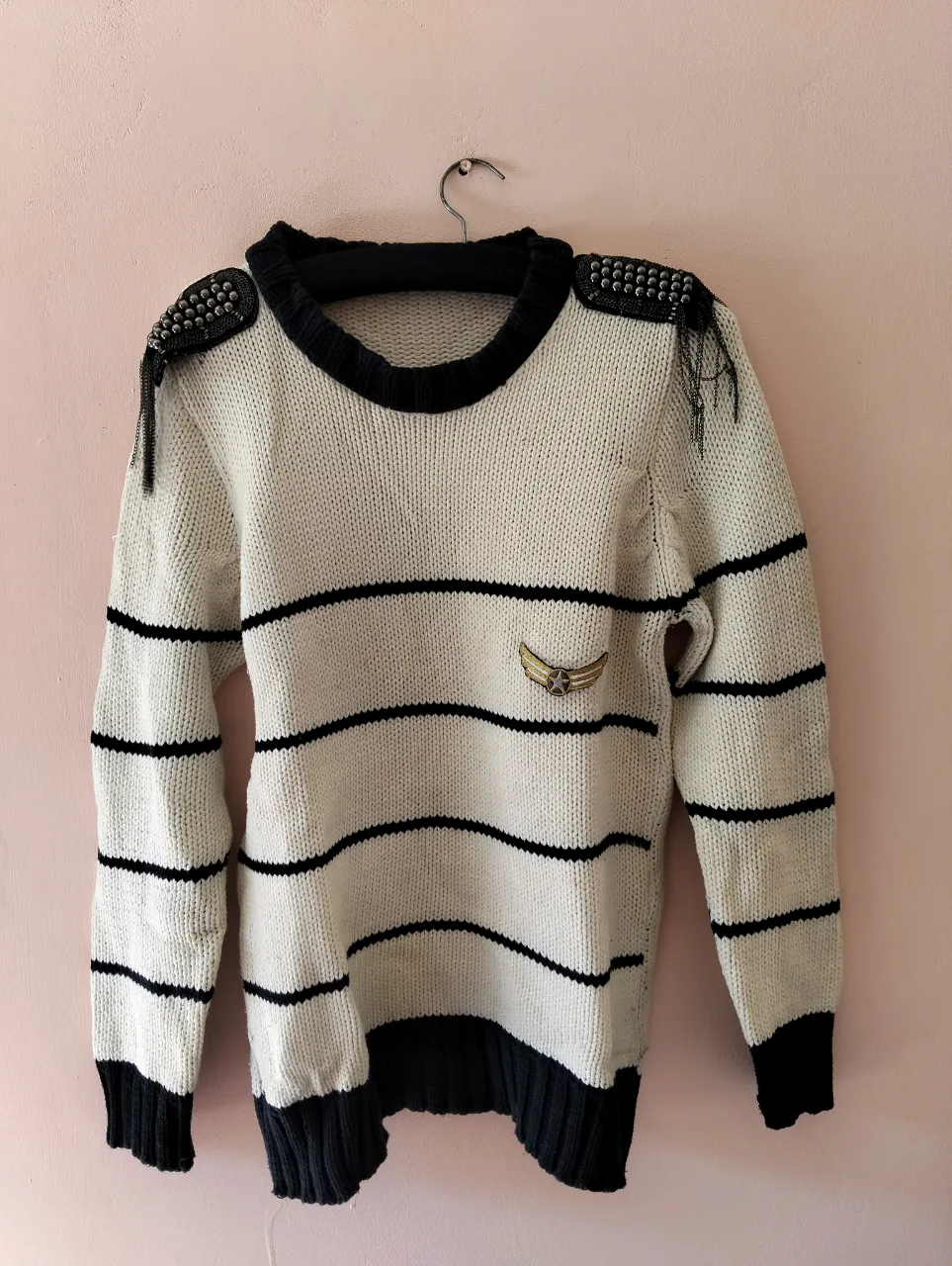 Sweater largo a rayas horizontales en color blanco y azul, con detalles de hombreras con tachas y cadenas. Ideal para un look rocker y canchero.