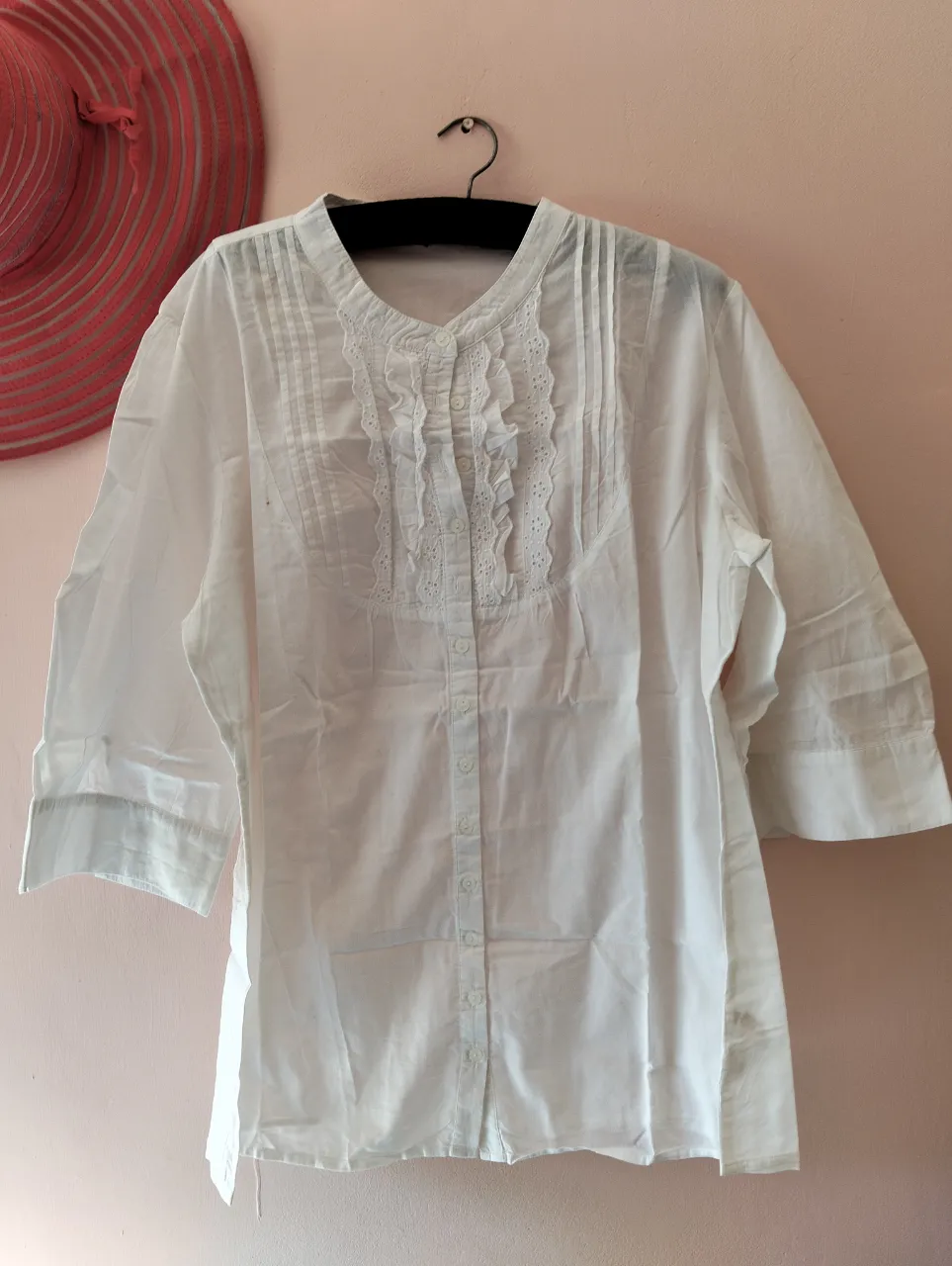 Blusa blanca de mujer, con cuello en V y detalles de encaje en el frente. Manga 3/4. Ideal para un look elegante y fresco.