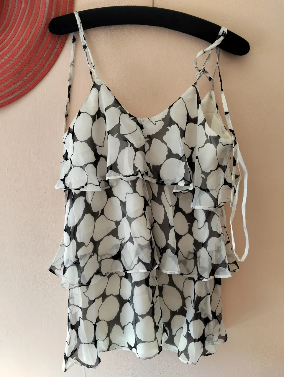 Top de mujer de gasa con estampado de lunares en blanco y negro. Diseño con volados y tiras ajustables. Ideal para un look fresco y moderno.