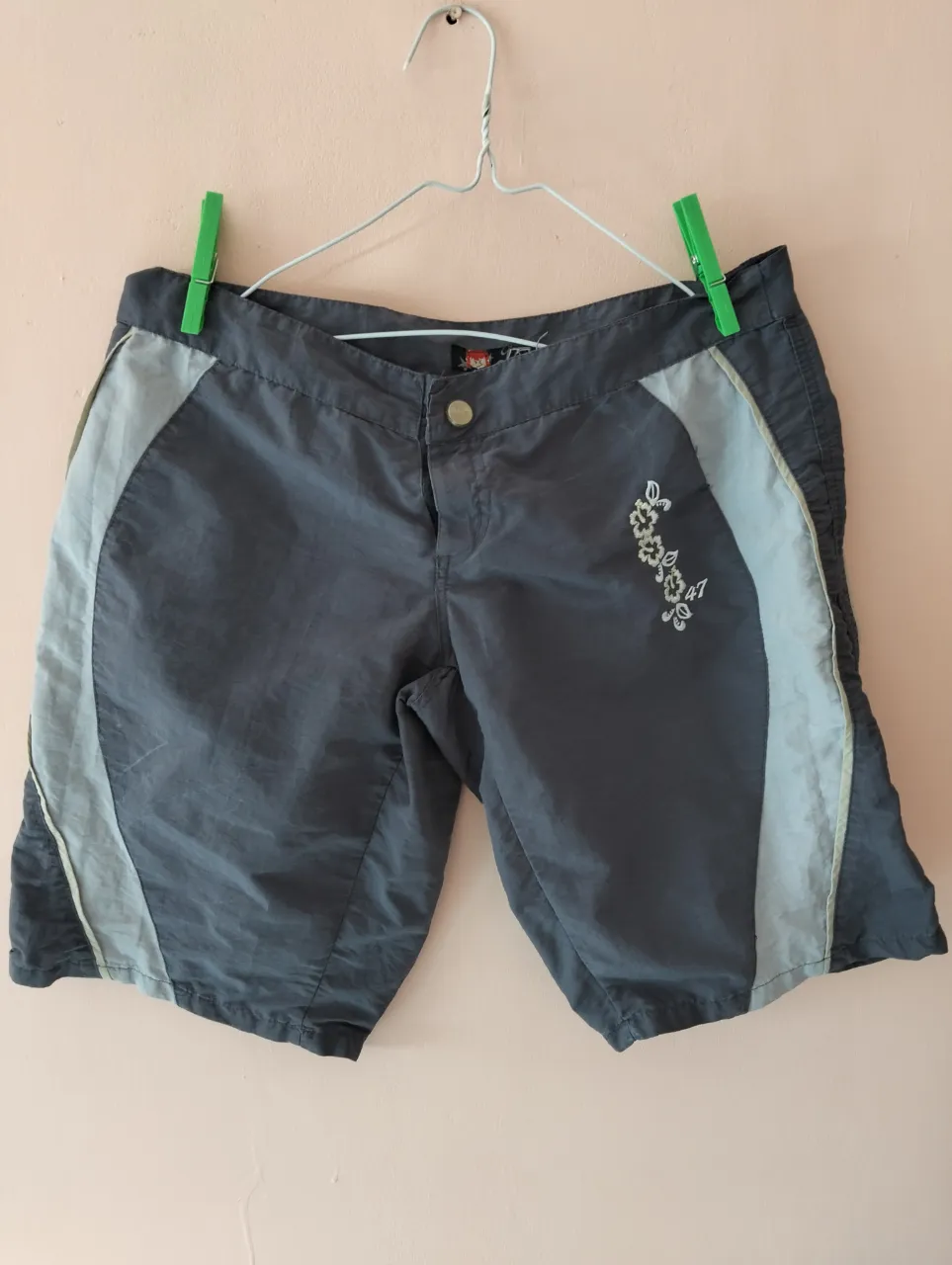 Short deportivo gris con detalles celestes y bordado floral. Ideal para actividades al aire libre.Tipo maya para el agua.