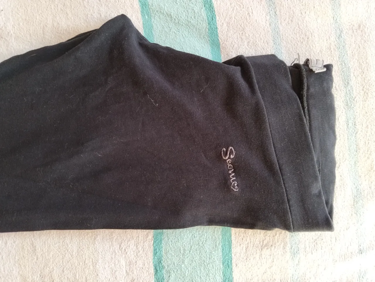 Pantalón de mujer negro, de tela suave y cómoda. Ideal para un look casual y relajado. Con el logo de la marca bordado en un lateral.