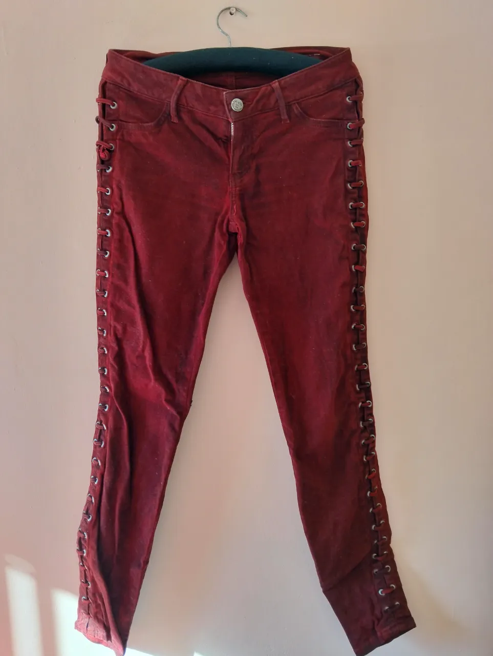 Jeans Guess bordo con detalles de cordones en los laterales. Tiro corto, corte skinny. Perfecto para un look moderno y audaz. Prende exclusiva