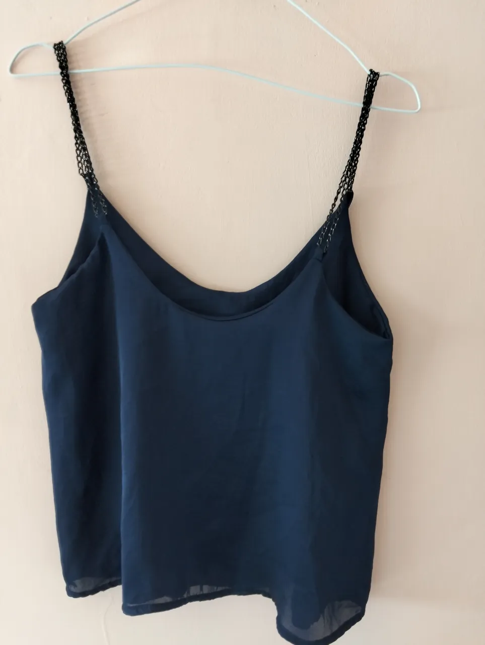 Top de mujer azul marino con tirantes finos negros. Ideal para combinar con faldas o pantalones de vestir. Perfecto para una salida casual o una ocasión especial.