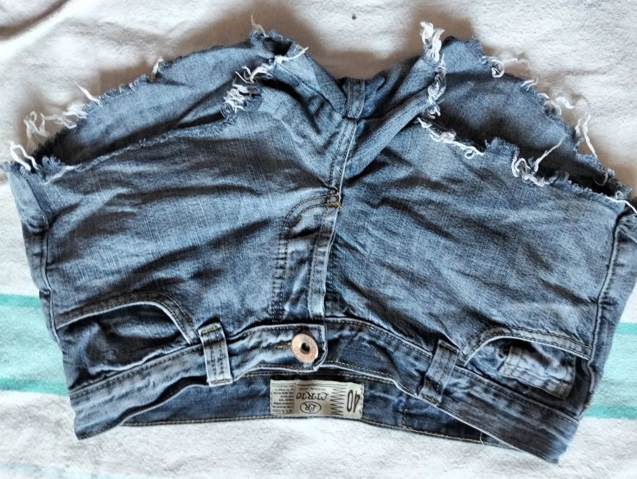Short de jean azul con detalles rotos y desflecado. Talle 40, ideal para un look casual y canchero.