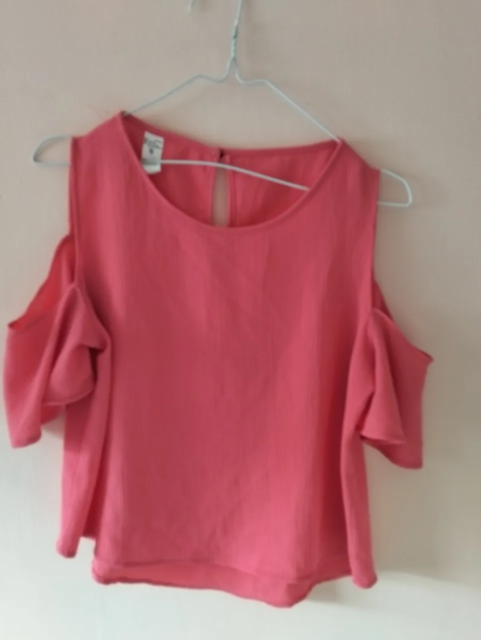 Blusa de mujer color rosa coral, con diseño de hombros descubiertos y mangas cortas con volados. Ideal para un look fresco y femenino.