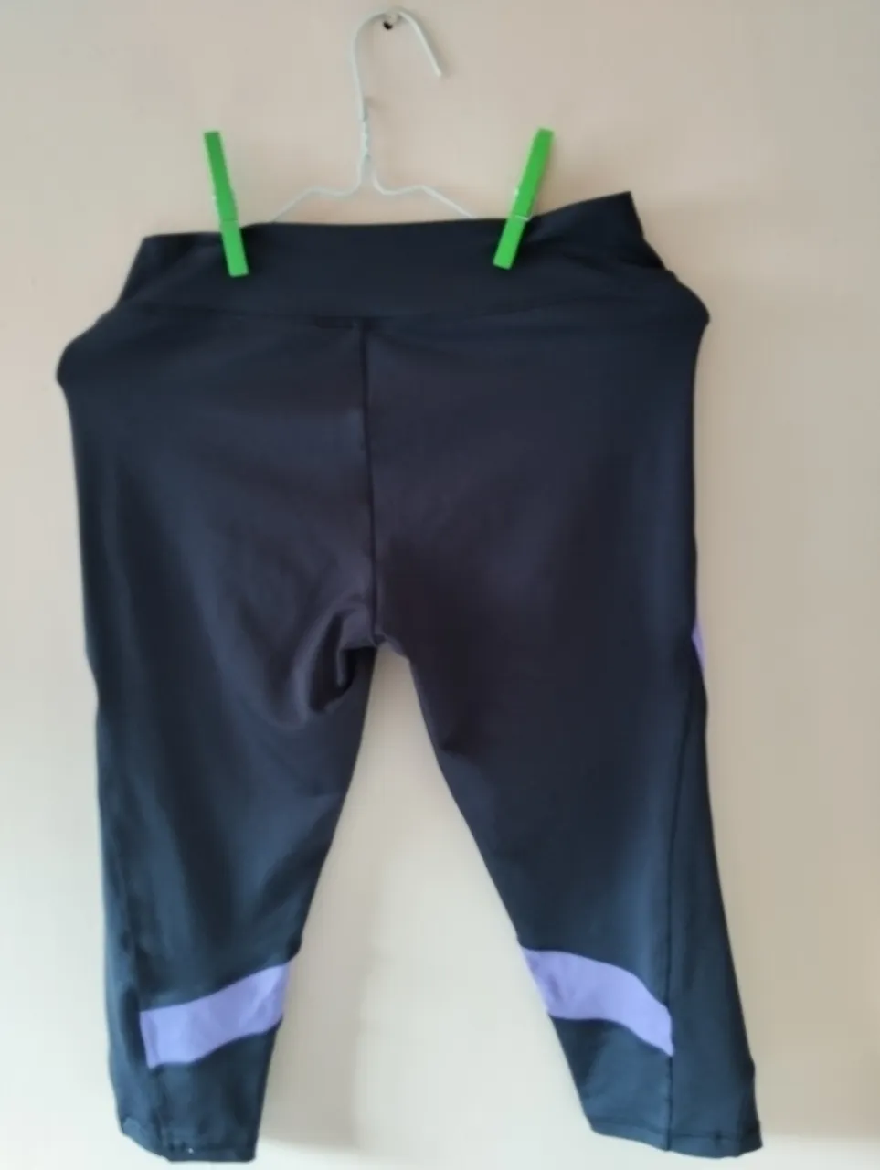 Calzas deportivas de mujer, color negro con detalles en violeta. Ideales para actividades físicas y entrenamiento. Diseño moderno y cómodo.