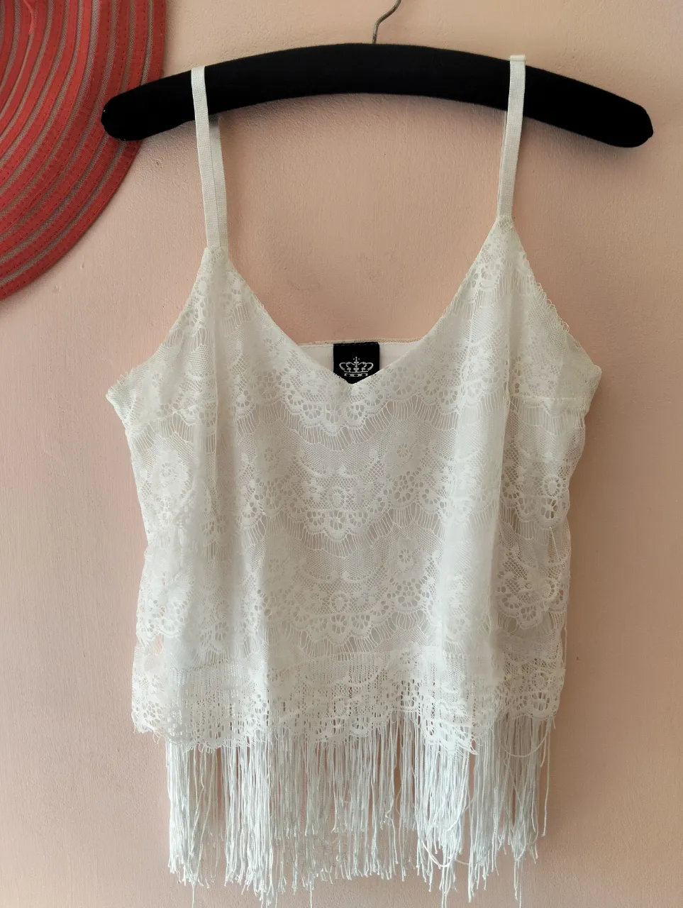 Top de encaje blanco con flecos en el bajo. Ideal para un look bohemio y fresco.