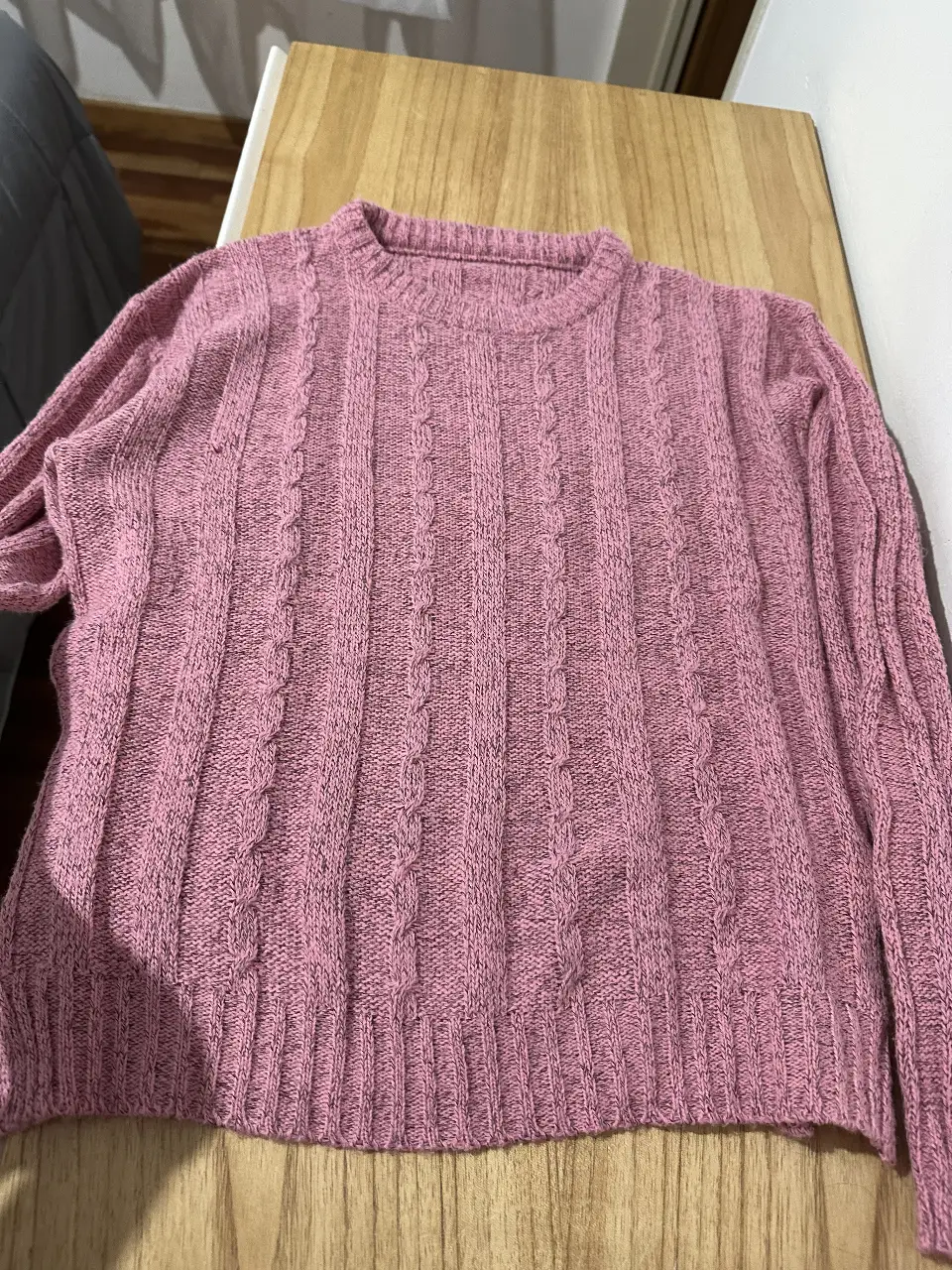 Sweater de punto rosa con diseño de trenzas. Ideal para un look casual.