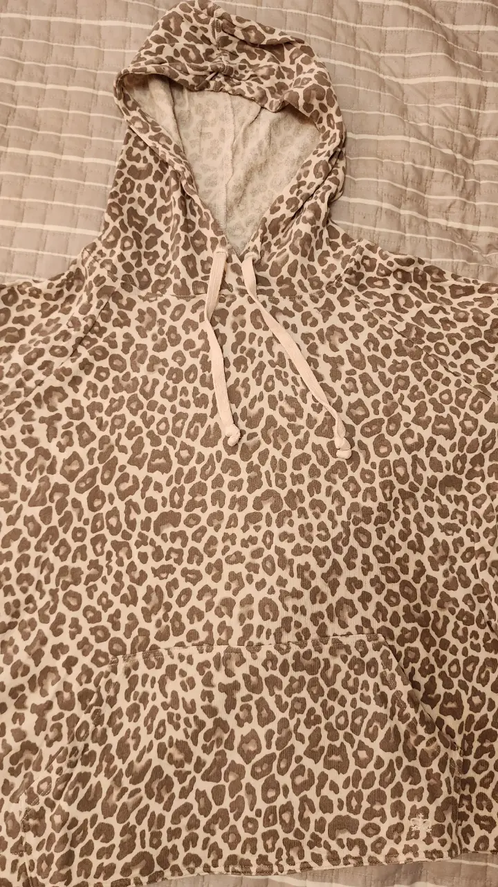 Buzo canguro con capucha y estampado de leopardo. Ideal para un look casual y canchero.