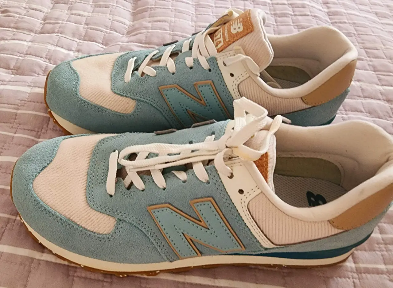 Zapatillas New Balance 574 celeste y blanco, ideales para un look casual y cómodo. Tienen un diseño clásico y atemporal, perfectas para el día a día.