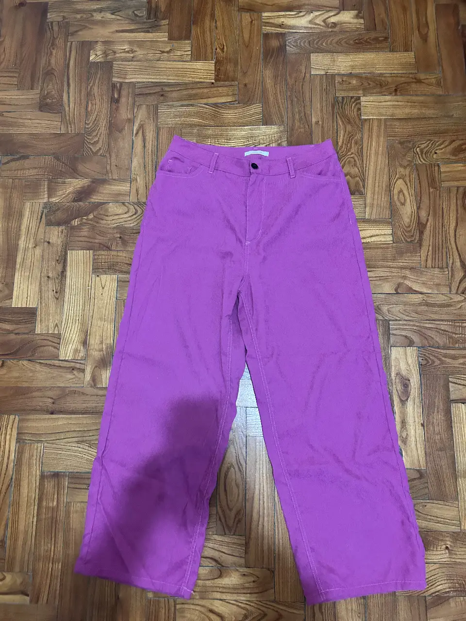 Pantalón sastrero de corderoy color fucsia, tiro alto, corte recto y bolsillos delanteros. Ideal para un look casual y moderno.