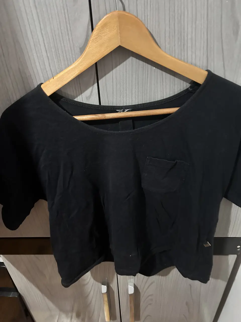 Remera negra de corte crop, con bolsillo en el pecho. Ideal para un look casual y moderno.