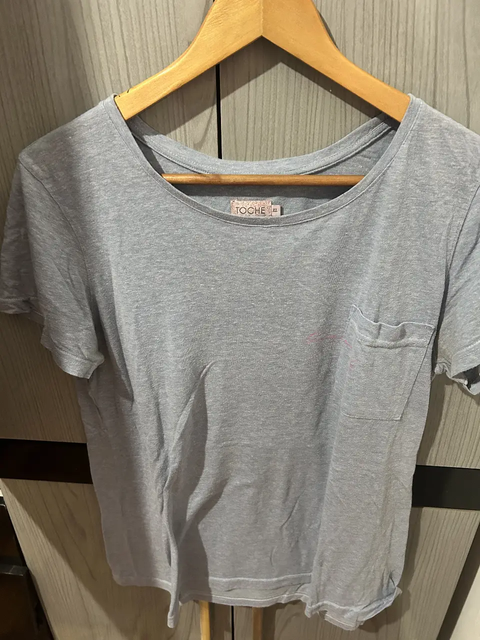 Remera gris de algodón con bolsillo y detalle de bordado. Talle XL. Ideal para un look casual y cómodo.