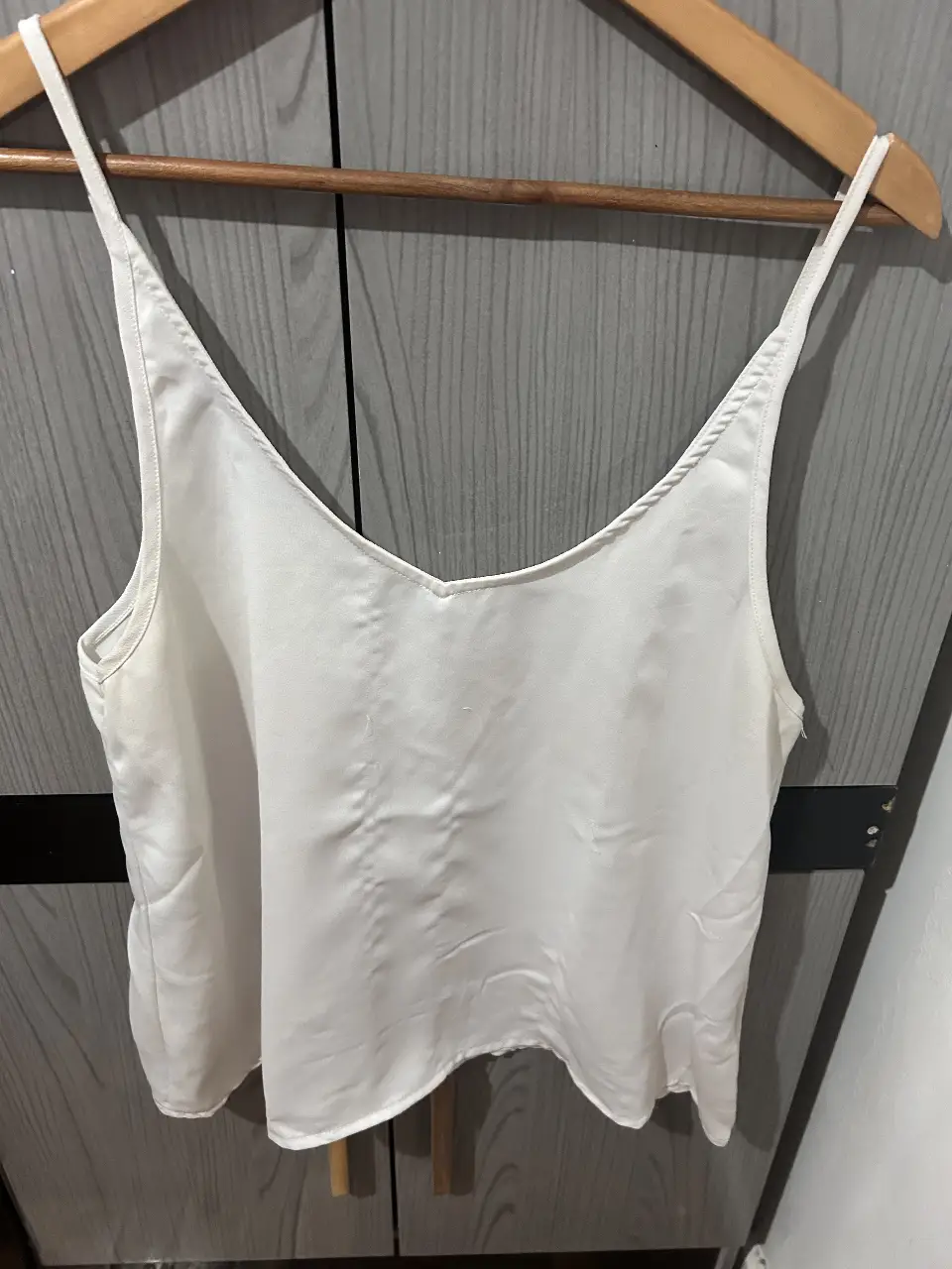 Top blanco con tirantes finos y escote en V, ideal para un look fresco y versátil. Perfecto para combinar con diferentes outfits.