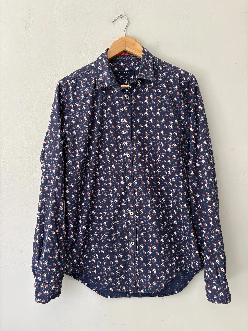 Camisa de hombre con estampa floral en tonos azules y rojos. Ideal para un look casual y moderno.