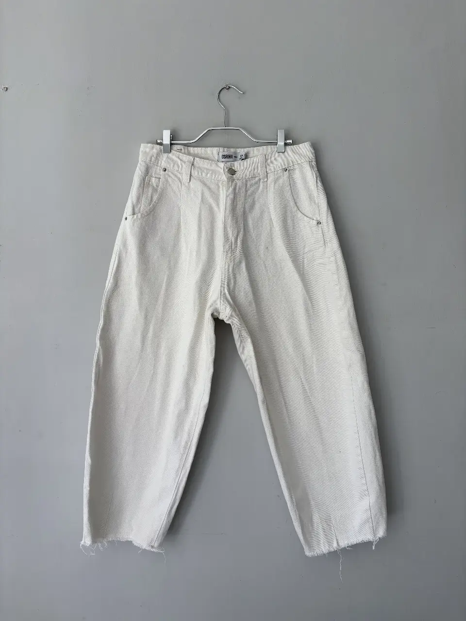 Jeans blancos de mujer, tiro alto, con etiqueta de la marca Osaina. Talle 38.