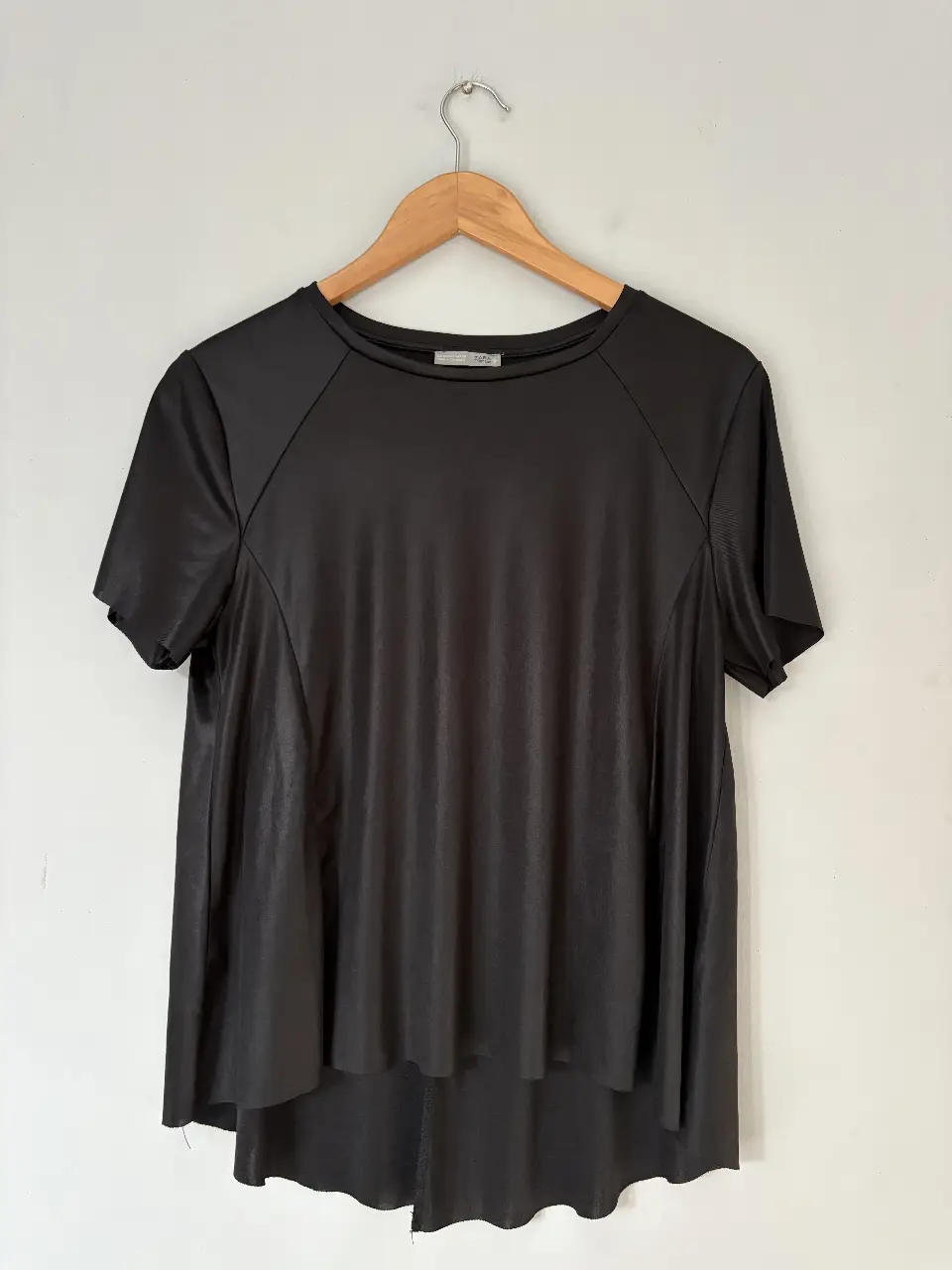 Blusa negra de la marca Zara, con mangas cortas y un diseño fluido. Ideal para un look casual y elegante.